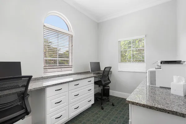 a view of a workspace with furniture and a window