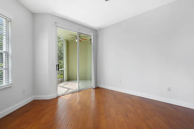 an empty room with wooden floor and entrance