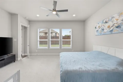 a spacious bedroom with a large bed and a flat screen tv