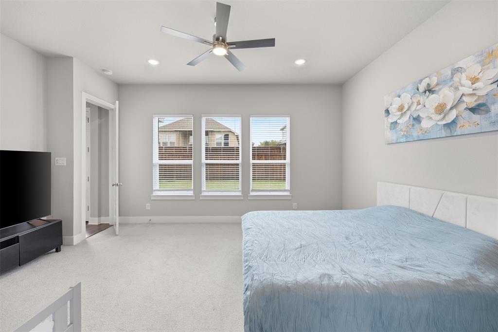 5805 Heatherwood Loop Sachse, TX 75048 - Photo 21 of 39 a spacious bedroom with a large bed and a flat screen tv