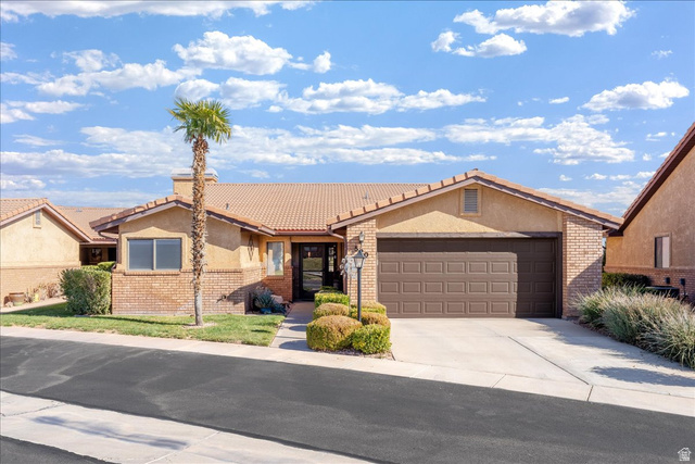 520 Ridge Rim Way St. George, UT 84770 - Photo 1 of 1 View of front facade with driveway, a tile roof, a garage, and stucco siding