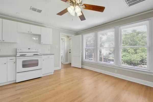 a view of a kitchen with a stove cabinets and a ceiling fan