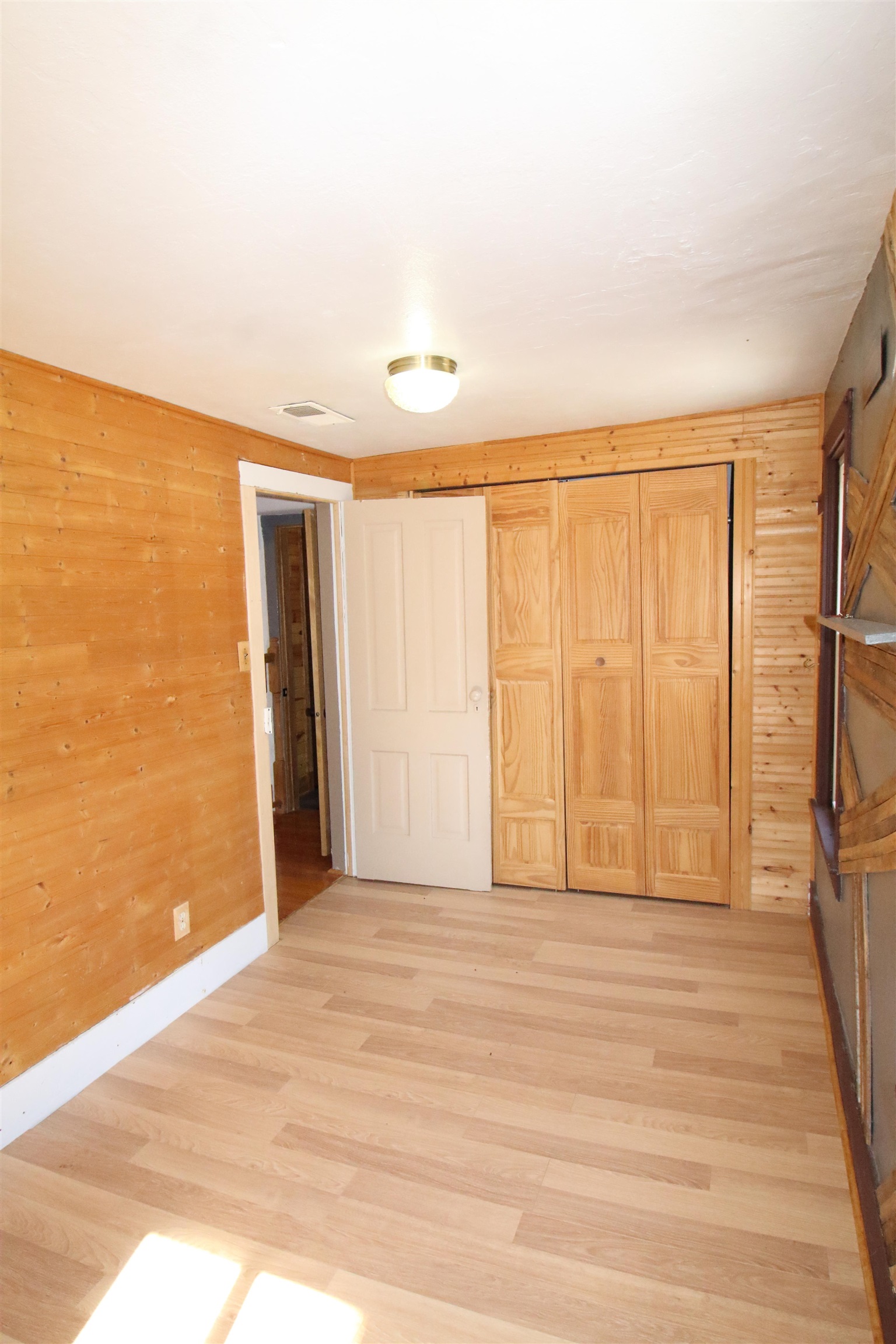 17896 Skunk Hollow Road Mount Carroll, IL 61053 - Photo 13 of 36 a view of an empty room with wooden floor and a window