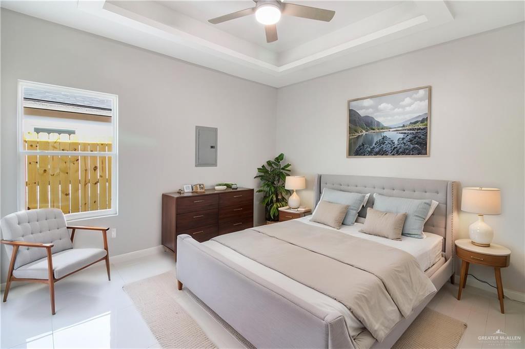 2002 East 1st Street, Unit 2 Mission, TX 78572 - Photo 7 of 15 Bedroom with electric panel, a ceiling fan, and a raised ceiling-property is virtually staged