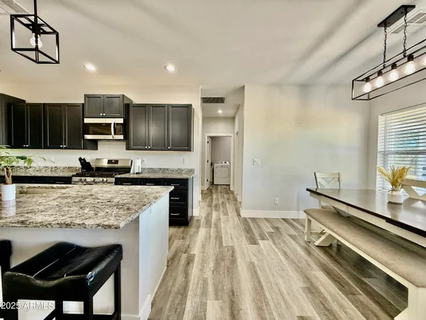 a kitchen with stainless steel appliances granite countertop a stove refrigerator sink and cabinets
