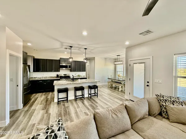 a living room with furniture kitchen view and a flat screen tv