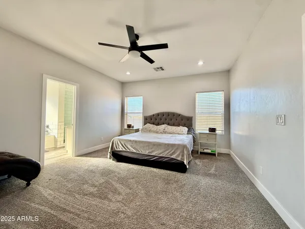 a bedroom with a bed chandelier and a window