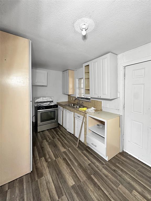535 Ella Avenue Dallas, TX 75217 - Photo 3 of 8 a kitchen with white cabinets and stainless steel appliances