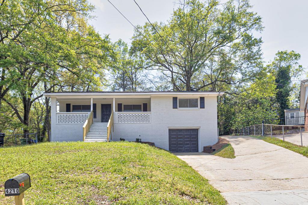 a view of a house with backyard and trees