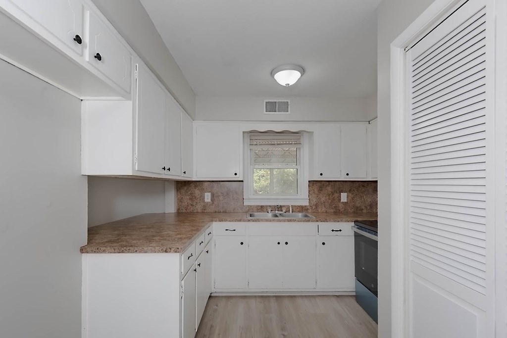 4270 Athens Court Columbus, GA 31907 - Photo 12 of 32 a kitchen with granite countertop a sink a stove and cabinets