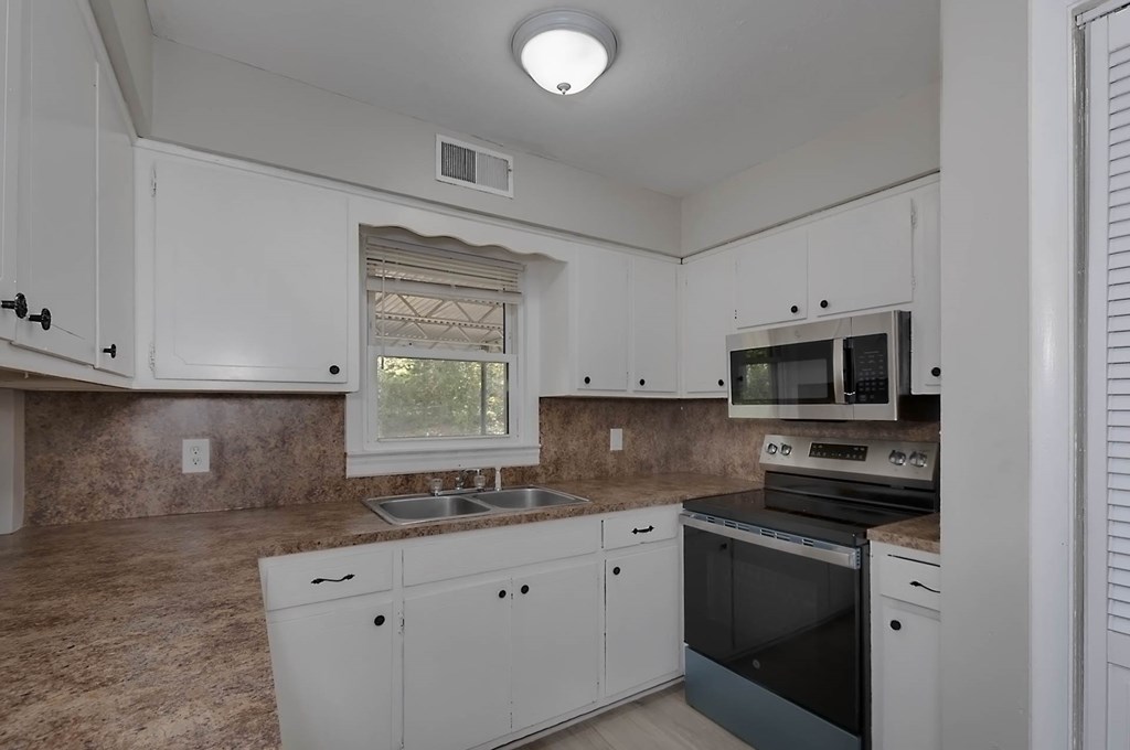 4270 Athens Court Columbus, GA 31907 - Photo 13 of 32 a kitchen with granite countertop a sink a stove and microwave
