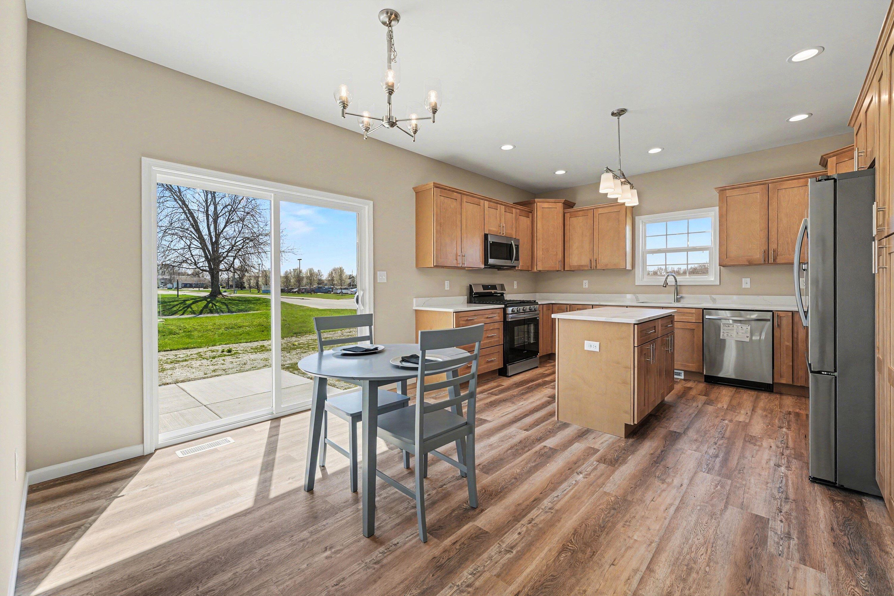 6065 Robbins Road Portage, IN 46368 - Photo 6 of 15 a kitchen with a table chairs refrigerator and microwave