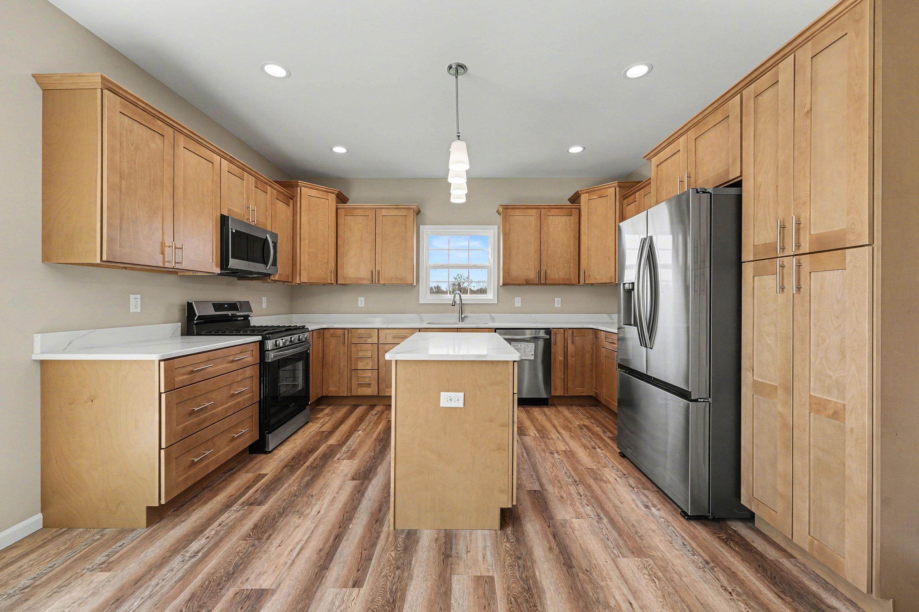 6065 Robbins Road Portage, IN 46368 - Photo 7 of 15 a kitchen with kitchen island granite countertop wooden cabinets a refrigerator a sink and a stove