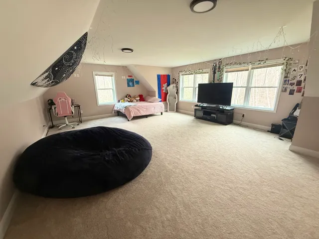 a bedroom with a large bed and a chandelier