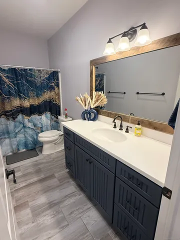 a bathroom with a toilet sink and mirror