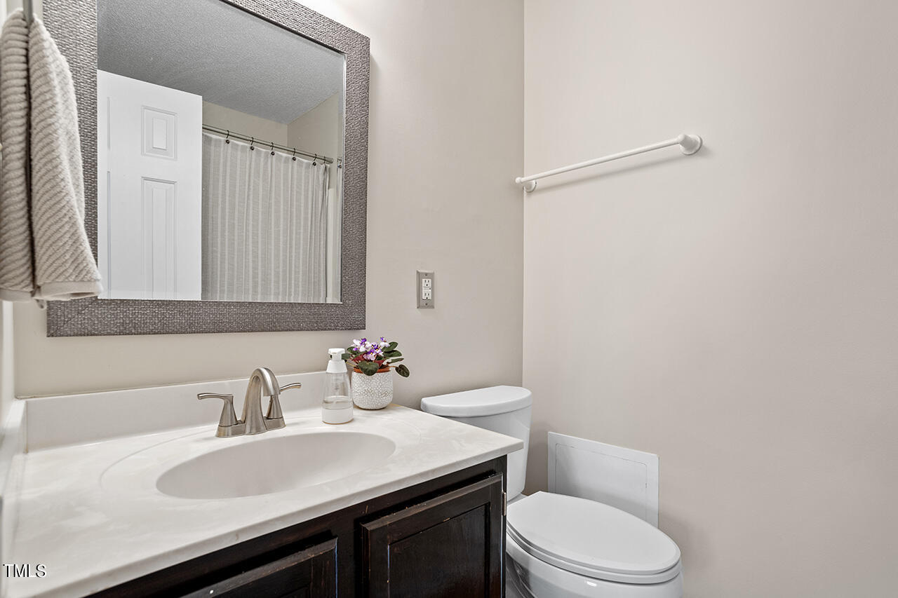 107 Long Shadow Place Durham, NC 27713 - Photo 25 of 31 a bathroom with a sink a toilet a mirror and vanity
