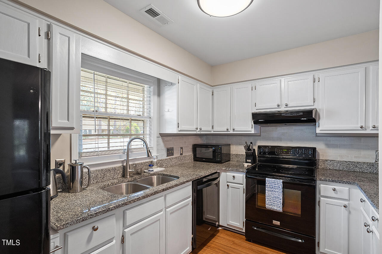 107 Long Shadow Place Durham, NC 27713 - Photo 7 of 31 a kitchen with granite countertop a sink a stove and cabinets