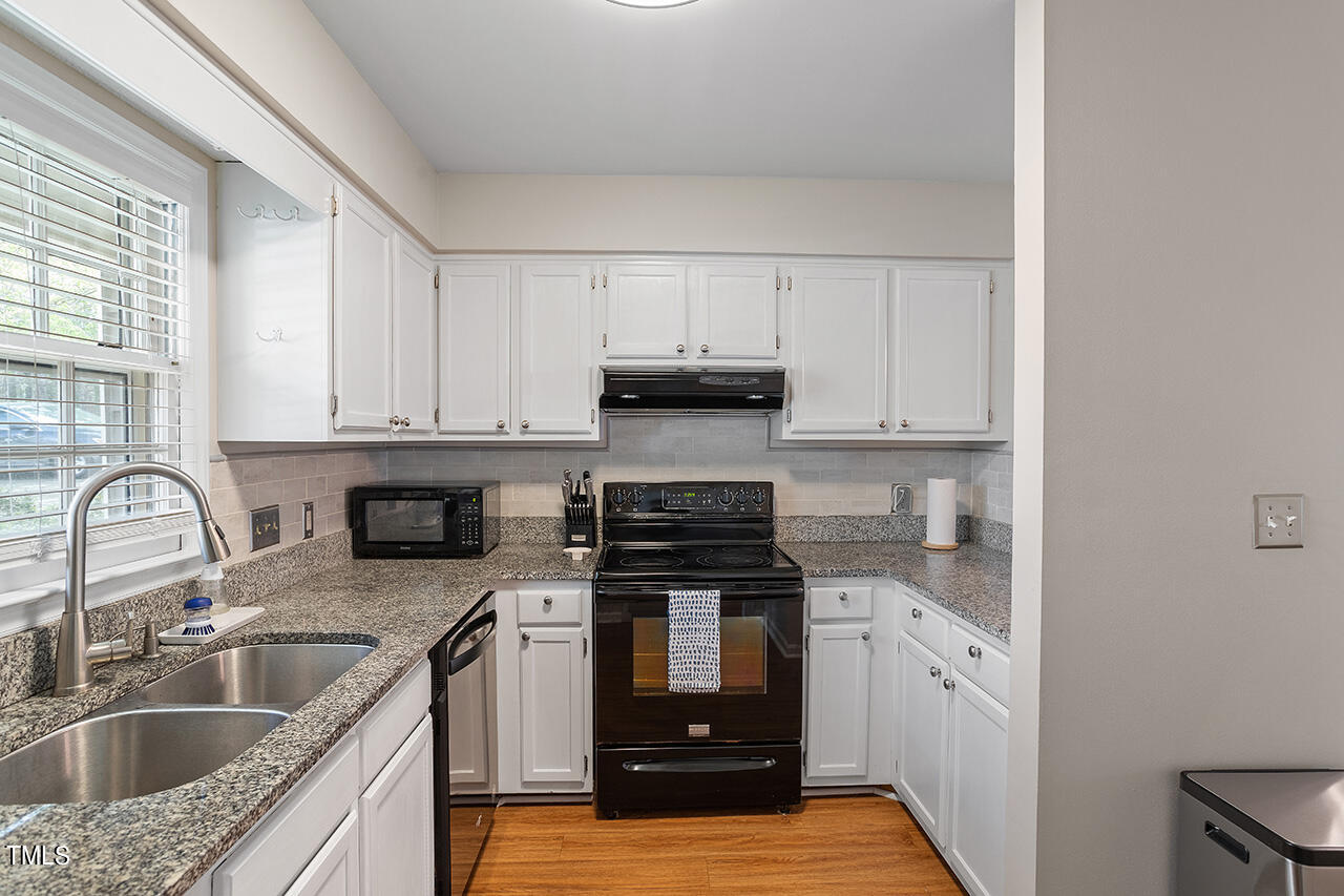 107 Long Shadow Place Durham, NC 27713 - Photo 8 of 31 a kitchen with granite countertop a sink stainless steel appliances and cabinets