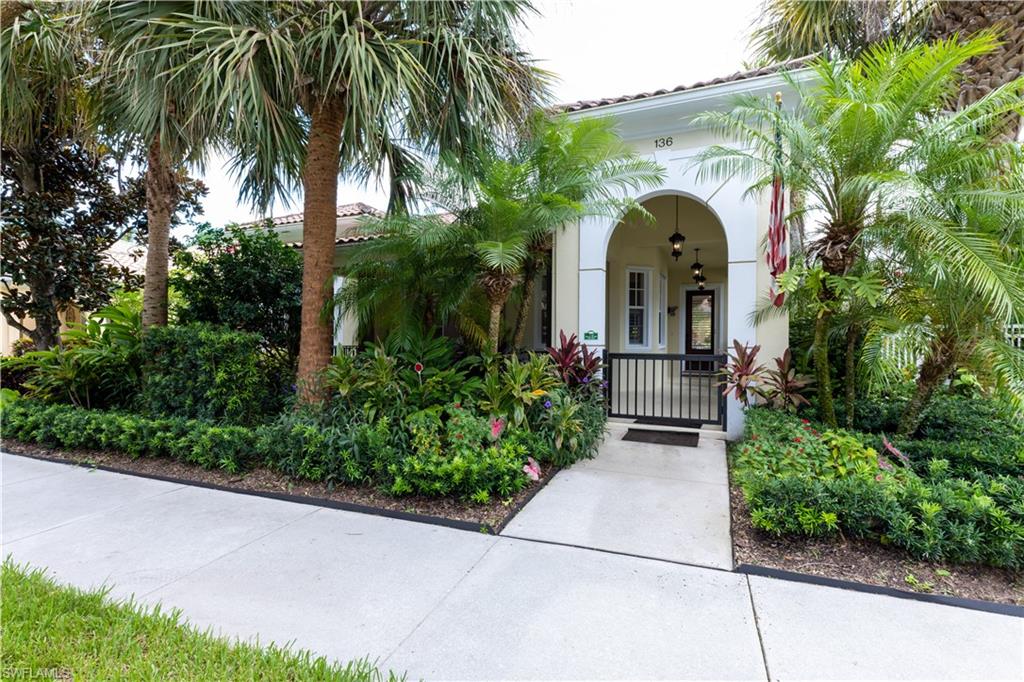 a front view of a house with plants and trees