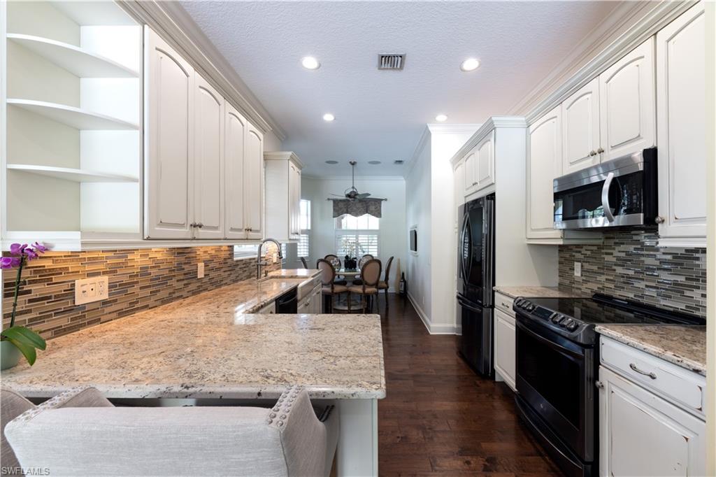136 Florence Drive Jupiter, FL 33458 - Photo 6 of 23 a kitchen with granite countertop a sink stainless steel appliances and white cabinets