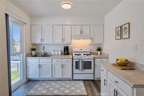 a kitchen with stainless steel appliances granite countertop a sink a stove and cabinets