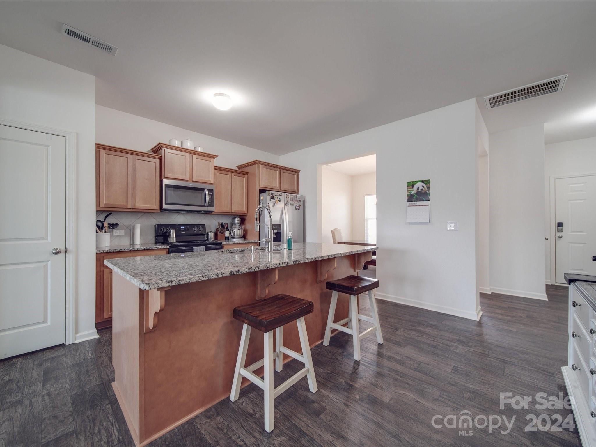 3824 Tersk Drive Midland, NC 28107 - Photo 12 of 39 a kitchen with kitchen island granite countertop wooden floors and stainless steel appliances