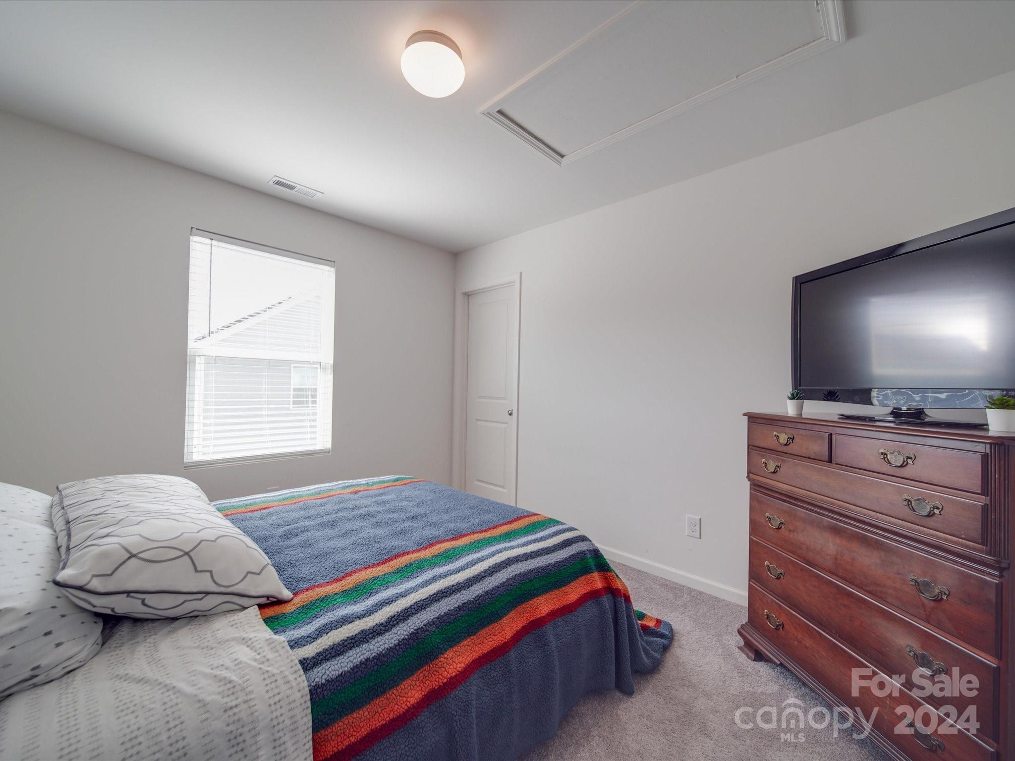 3824 Tersk Drive Midland, NC 28107 - Photo 24 of 39 a bedroom with a bed and a flat screen tv