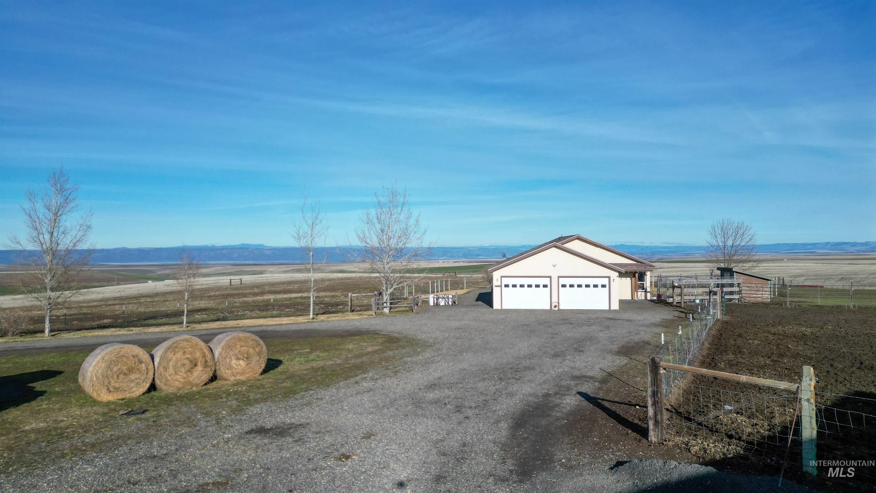 19397 Cloverland Road Asotin, WA 99402 - Photo 25 of 35 View of front of home with a rural view, an outdoor structure, a garage, and driveway