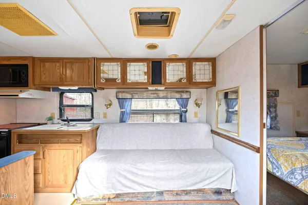 a large bedroom with a large bed a flat tv screen and a bookshelf