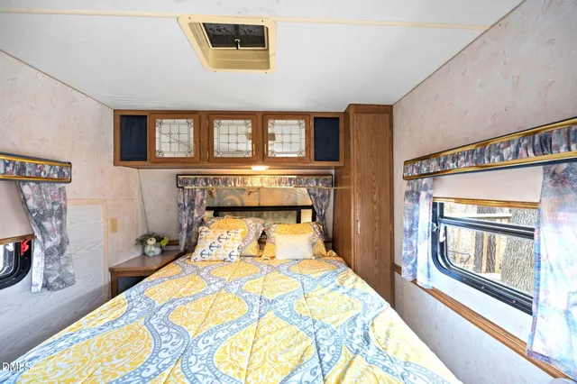 a bedroom with a bed and a large window