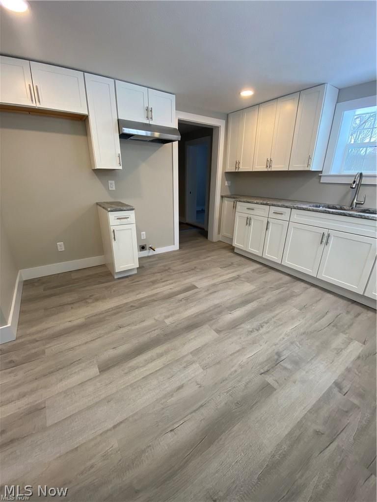 2803 State Road Vermilion, OH 44089 - Photo 12 of 28 Kitchen with brand new white cabinets, light wood-style flooring, recessed lighting, exhaust hood, large sink and granite counters