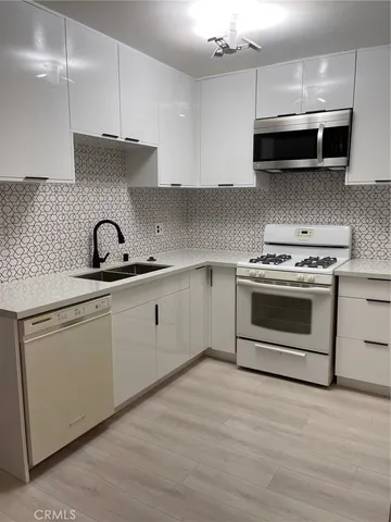a kitchen with a sink stove and cabinets
