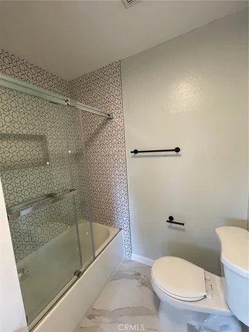 a bathroom with a toilet and a shower