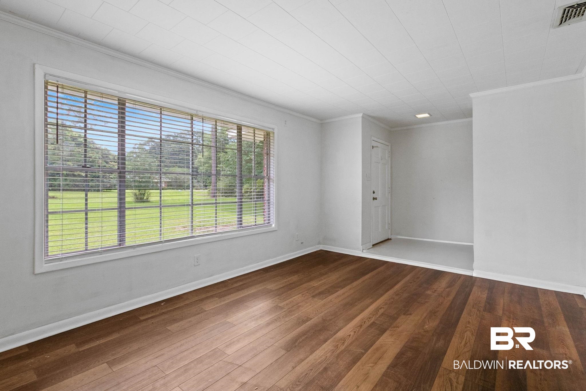 384 Old Bratt Road Atmore, AL 36502 - Photo 30 of 64 Expansive window with horizontal blinds, offering views of a broad green landscape