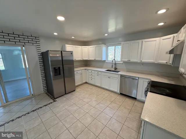 a kitchen with a sink a refrigerator and cabinets
