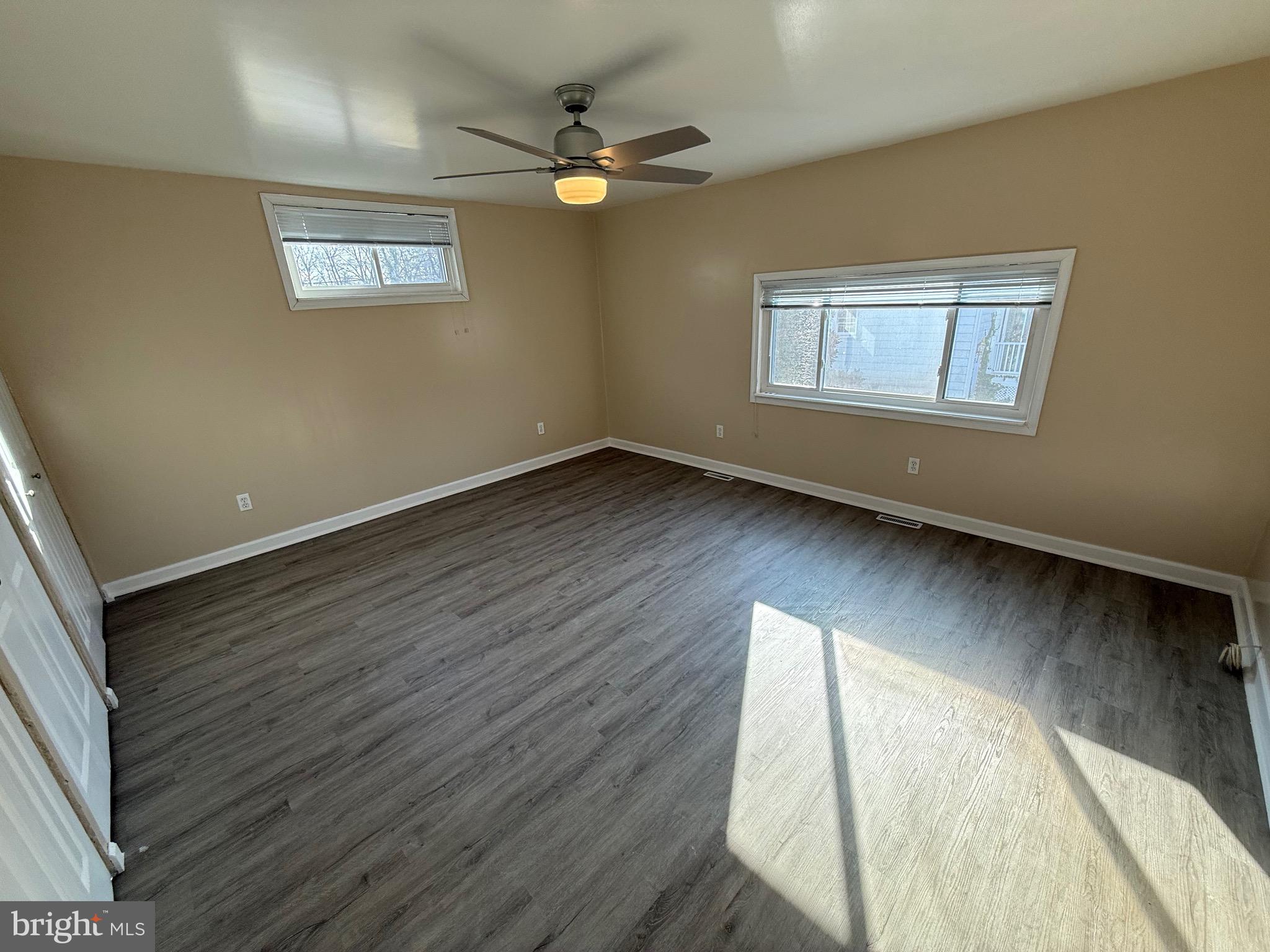 1214 Reece Road Severn, MD 21144 - Photo 16 of 25 an empty room with wooden floor fan and windows
