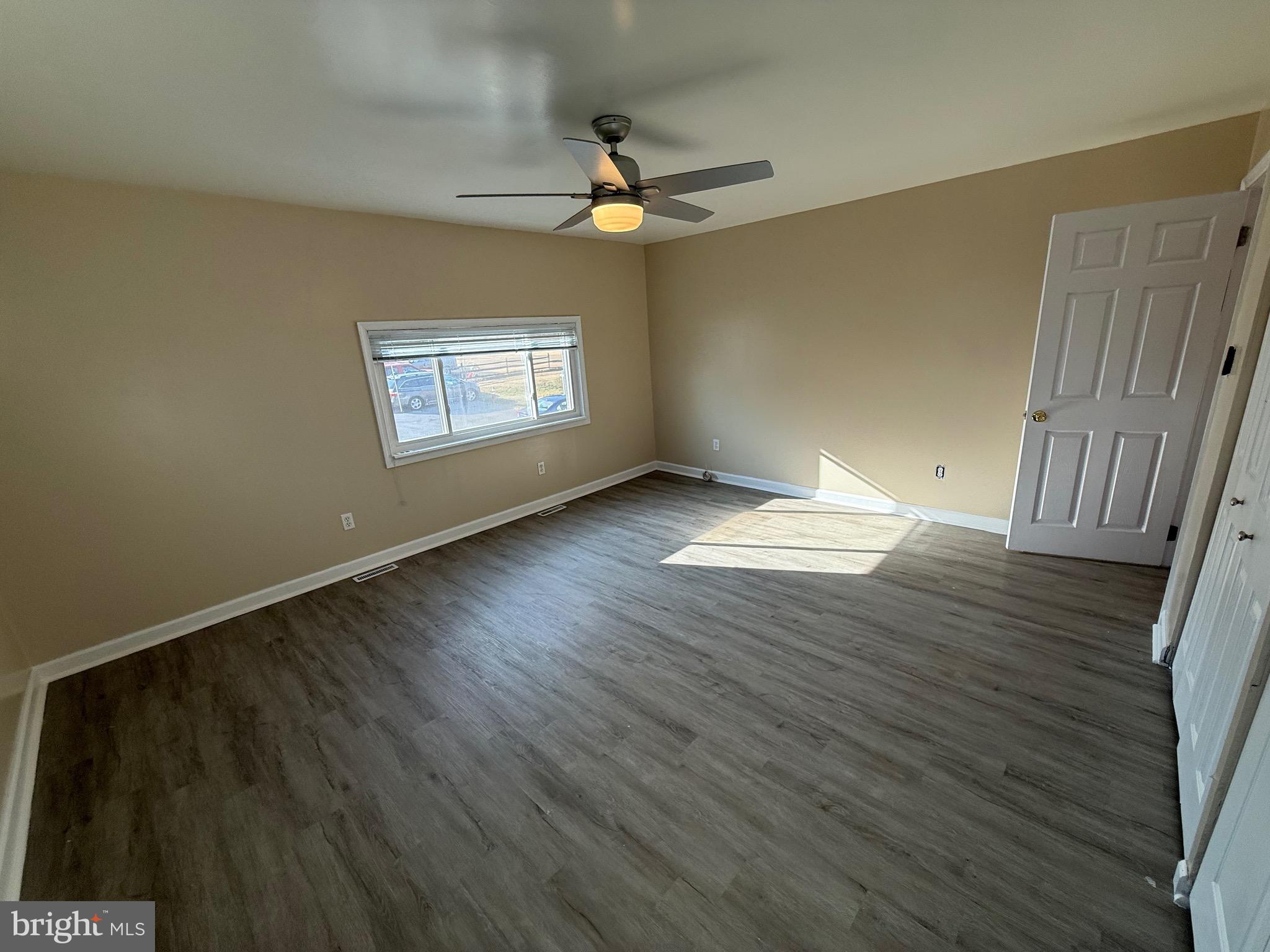 1214 Reece Road Severn, MD 21144 - Photo 18 of 25 a view of an empty room with wooden floor and a window