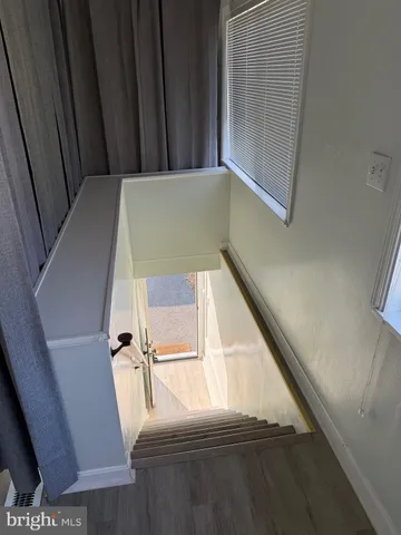 an empty room with wooden floor and a bathroom