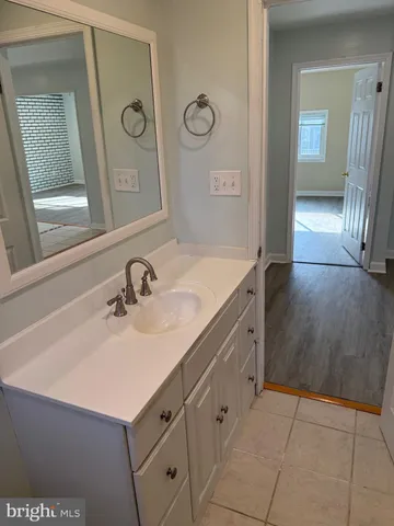 a bathroom with a granite countertop sink a mirror and shower