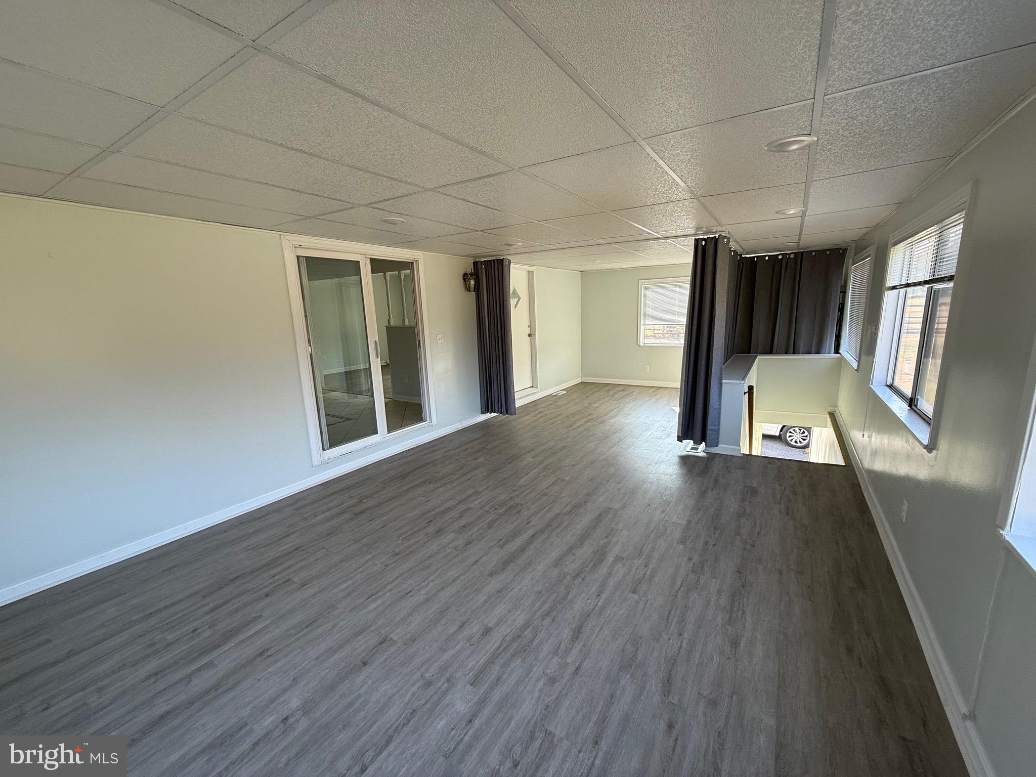 1212 Reece Road Severn, MD 21144 - Photo 4 of 25 a view of an empty room with wooden floor and a window