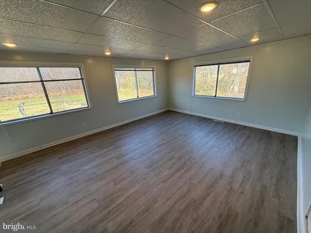an empty room with wooden floor and a window
