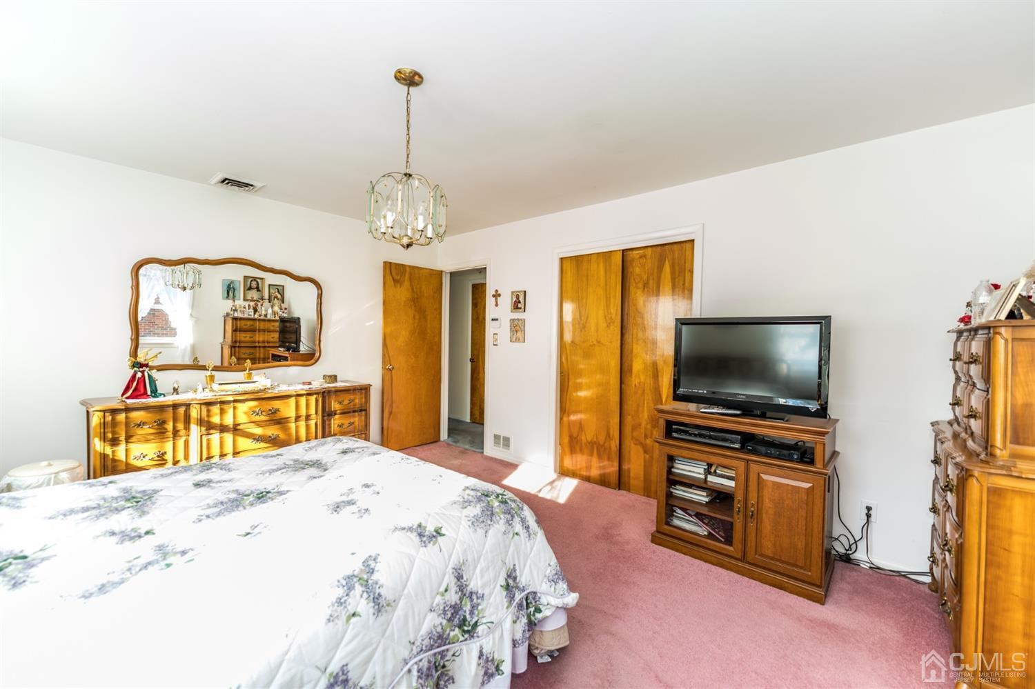283 Baltusrol Way Springfield, NJ 07081 - Photo 14 of 20 a bedroom with a bed and a flat screen tv