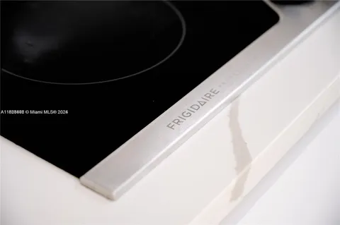 a living room with kitchen island and white cabinets