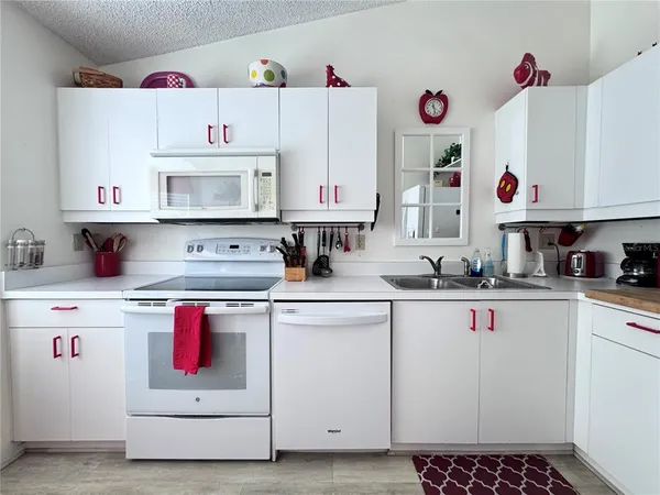 a kitchen that has a lot of cabinets and wooden floor
