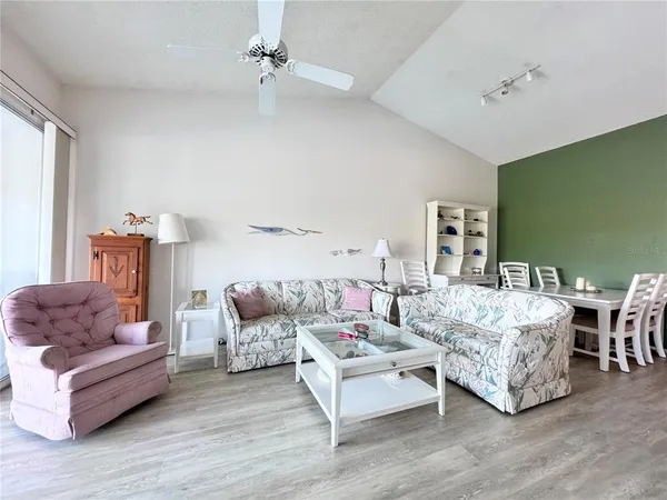 a dining room with a wooden floor and stainless steel appliances