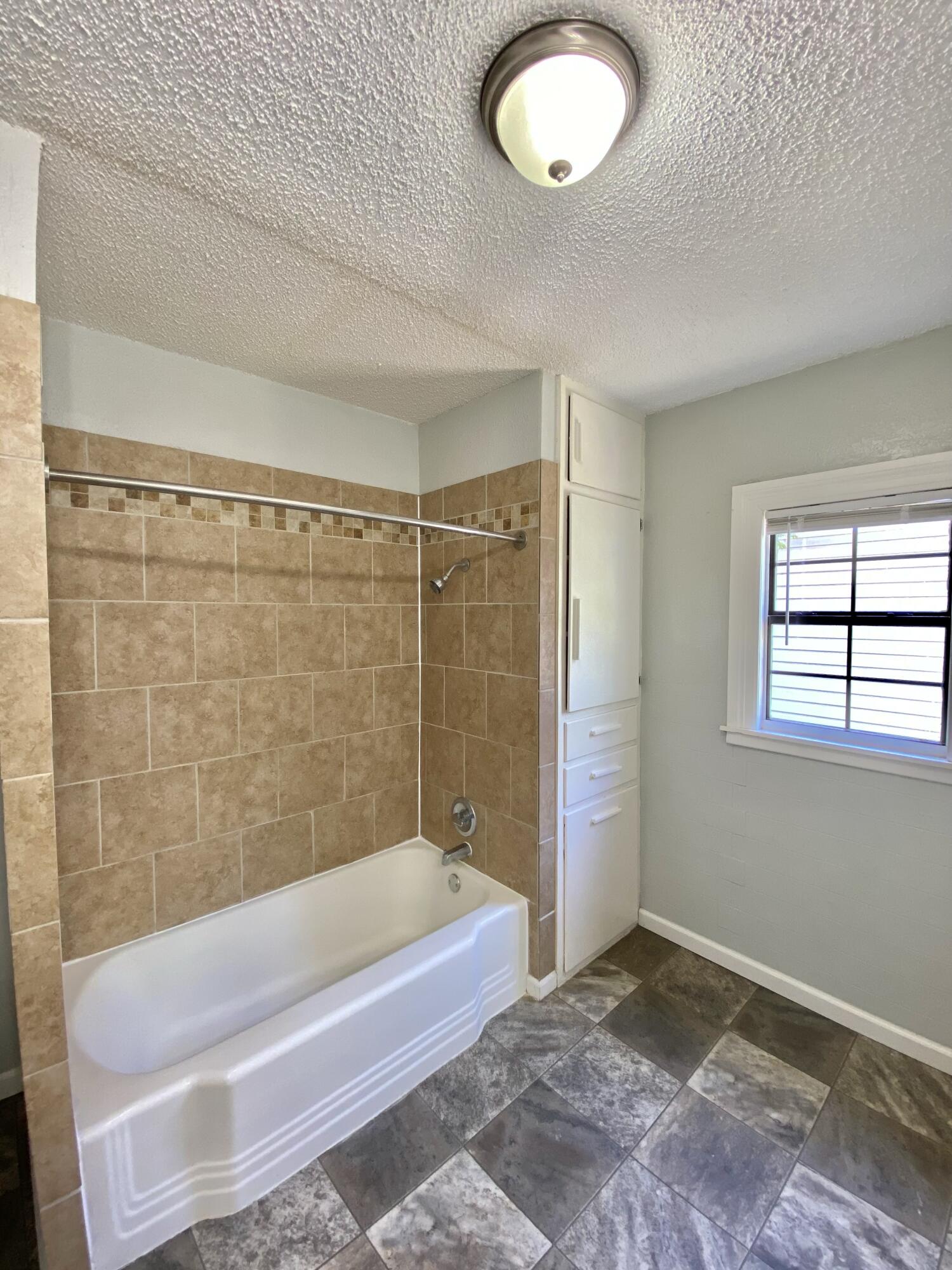 2209 28th Street Lubbock, TX 79411 - Photo 11 of 12 a bathroom with a tub and a shower