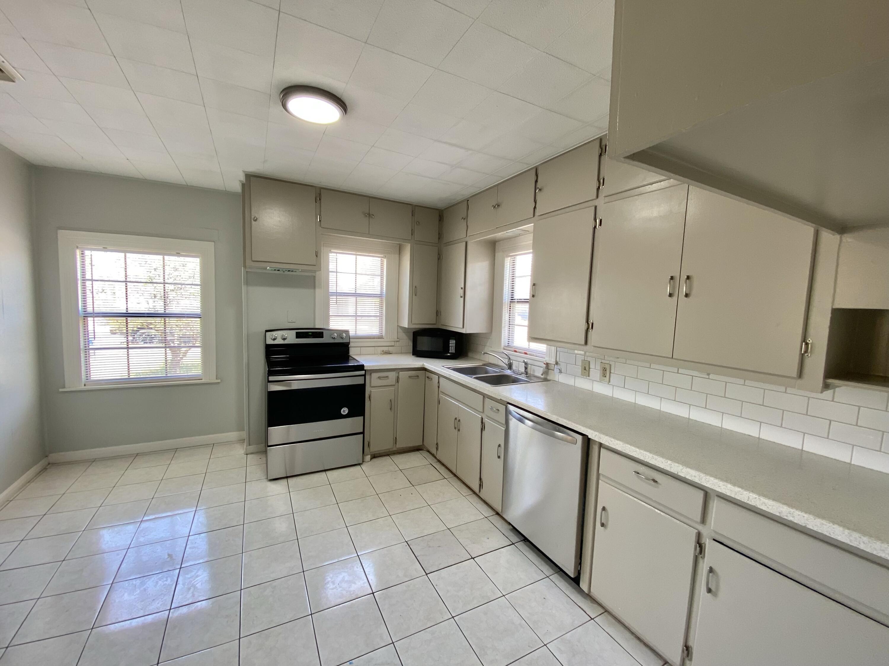2209 28th Street Lubbock, TX 79411 - Photo 4 of 12 a large kitchen with a stove and a sink