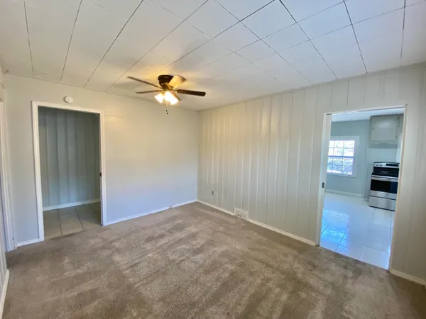 an empty room with fan and entrance