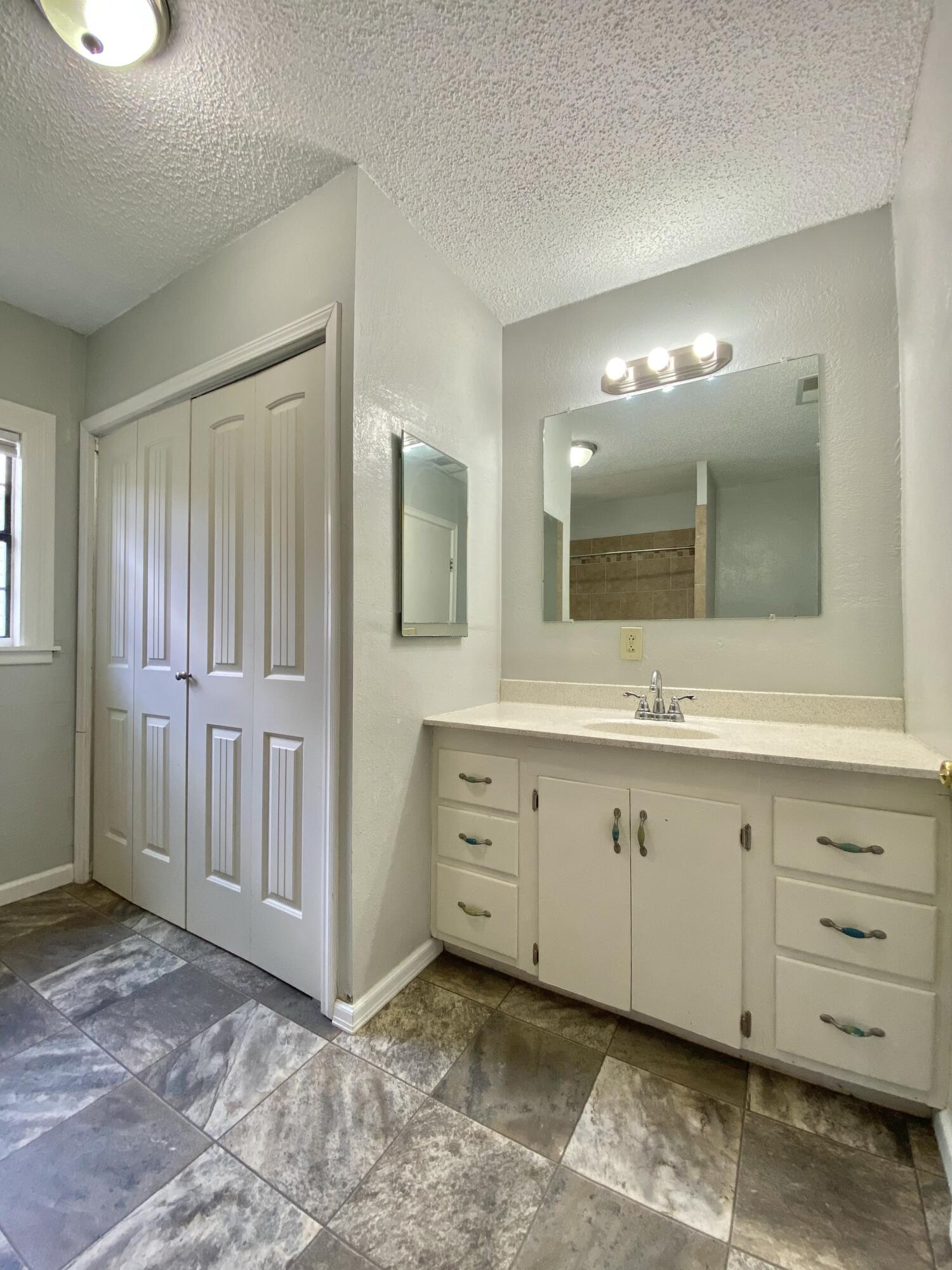 2209 28th Street Lubbock, TX 79411 - Photo 10 of 12 a spacious bathroom with a mirror sink and cabinets