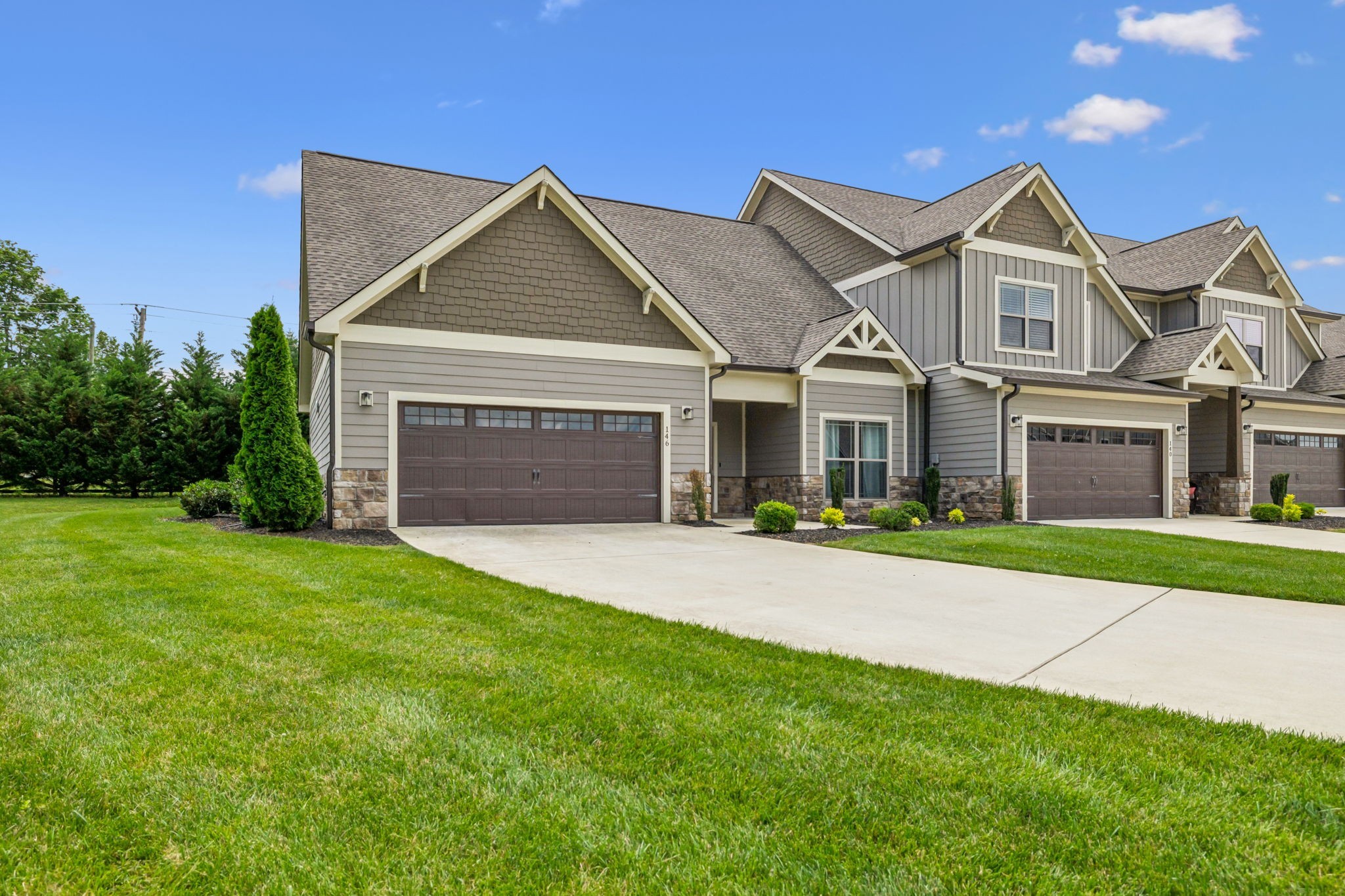 a front view of a house with a garden and yard